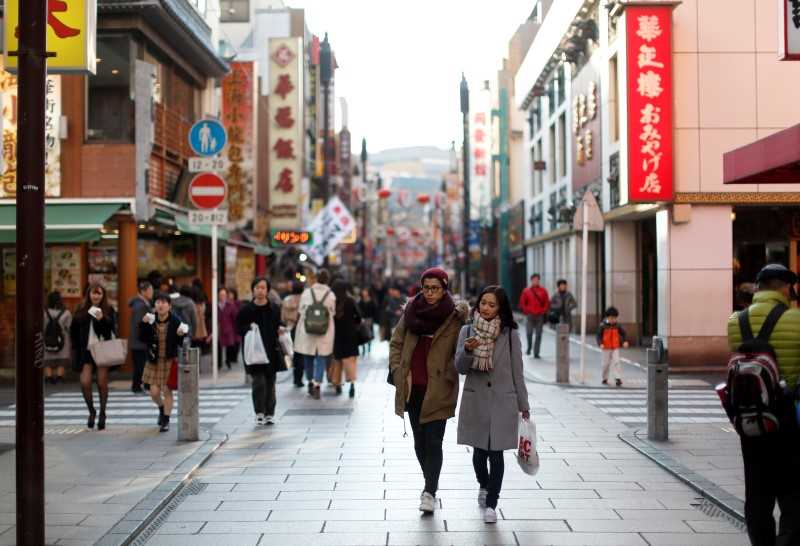 A shopping street in Japan with pedestrians pictured